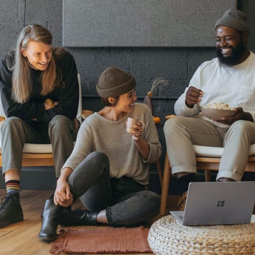 friends sit together around an open laptop