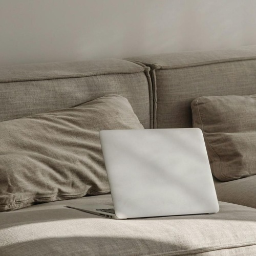 a couch with pillows and a laptop