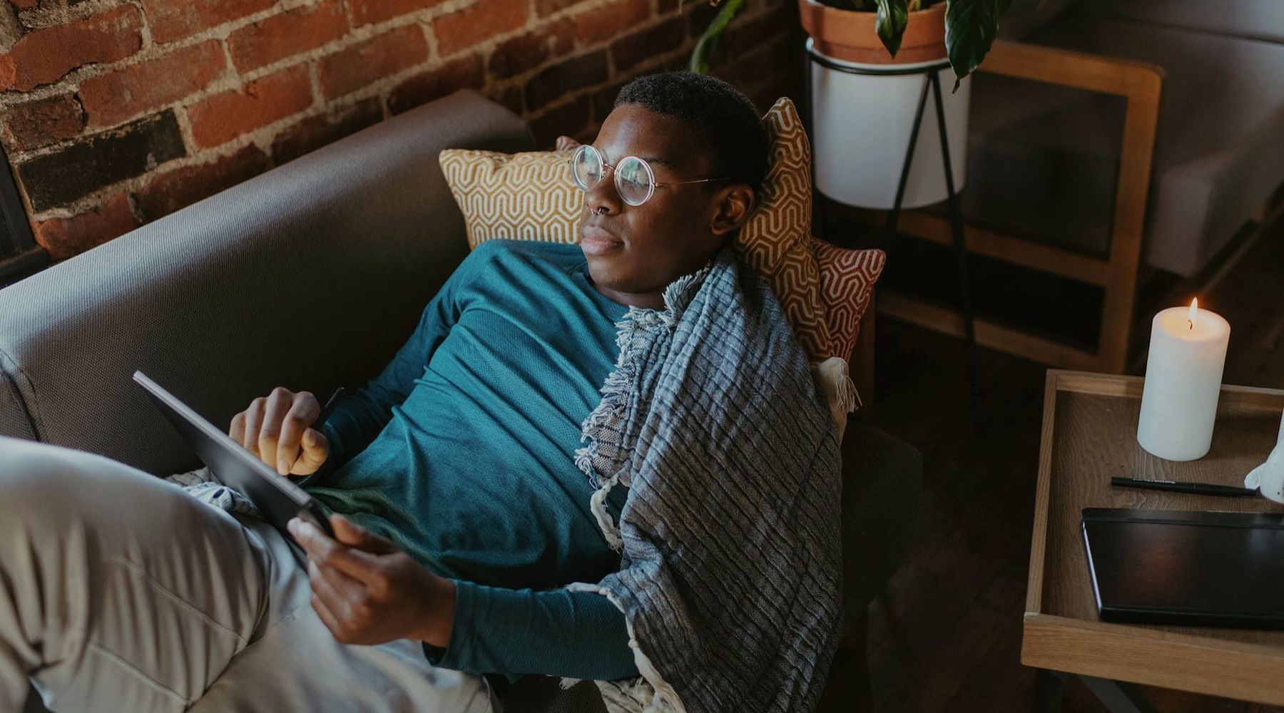 a man looks at his tablet while lying on his living room couch